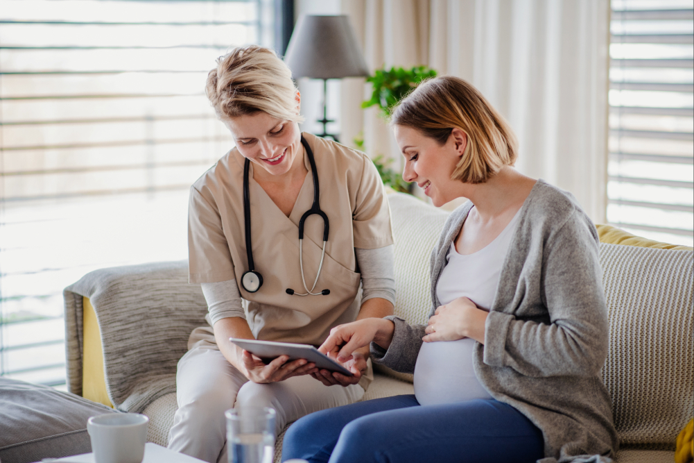 Pregnant woman and a nurse looking at a form.
