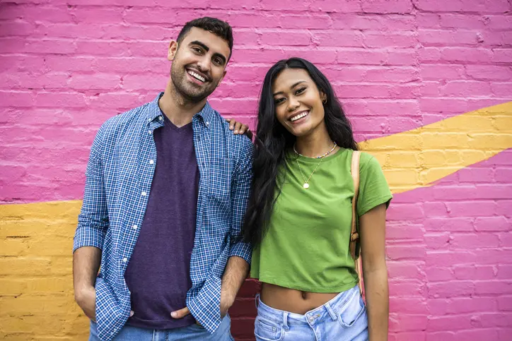 Young couple standing in front of a colorful wall