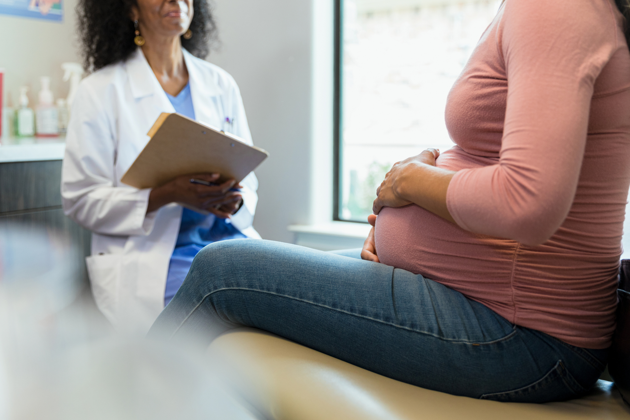 Pregnant woman and female doctor have discussion during appointment